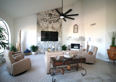 A living room with a fireplace and a ceiling fan.