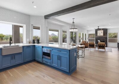 A kitchen with blue cabinets and hardwood floors.