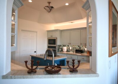 A view of a kitchen through an archway.