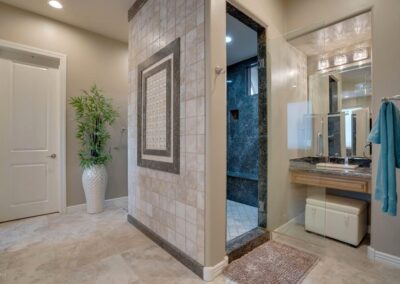 A bathroom with a walk in shower and sink.