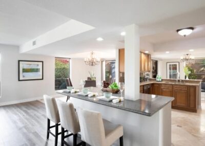 A kitchen with hardwood floors and a bar area.