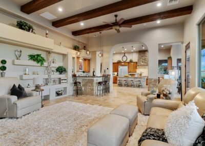 A large living room with beige furniture and ceiling beams.