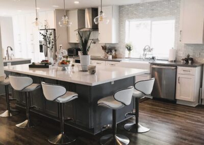 A kitchen with a large island and bar stools.